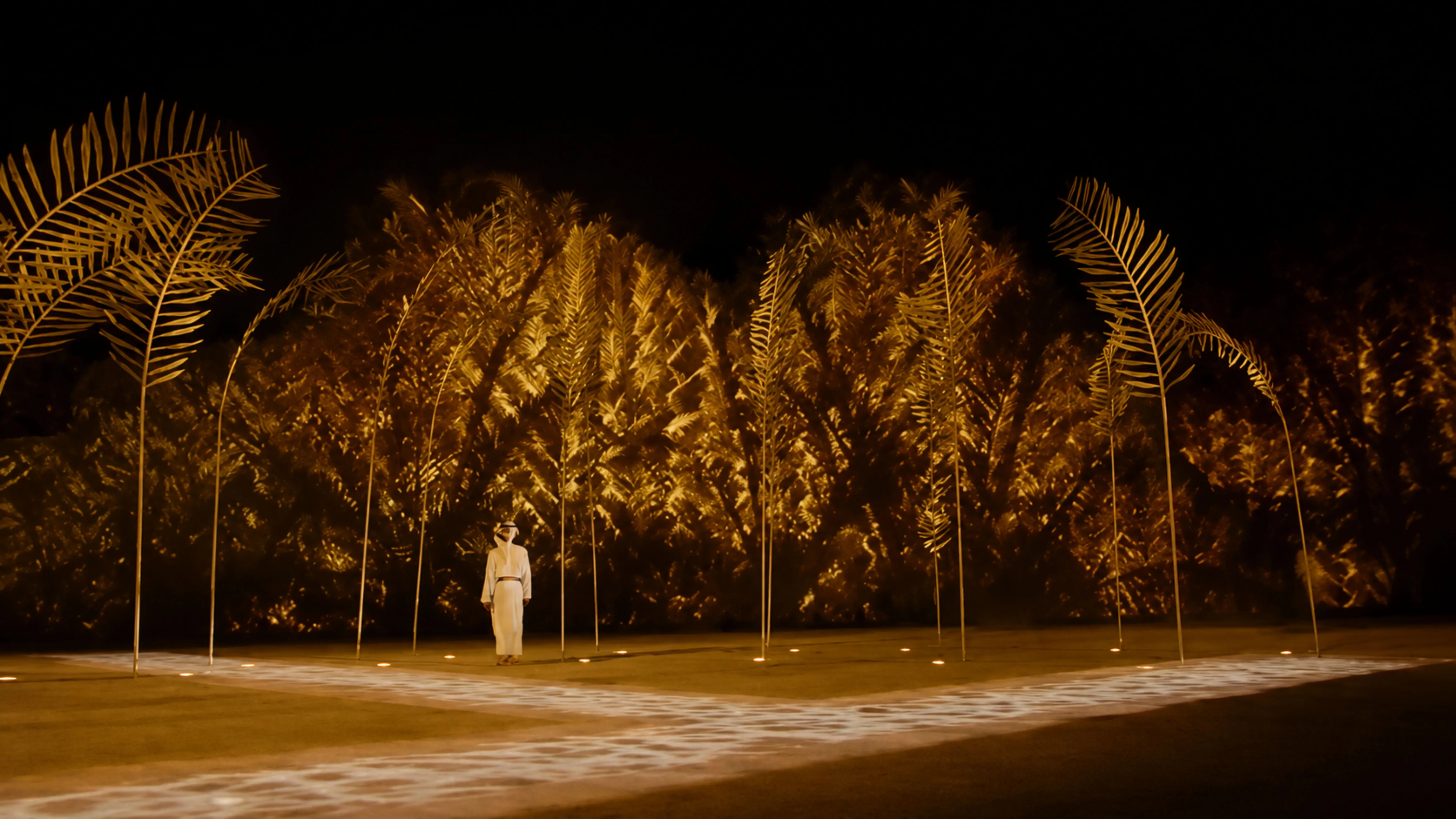 The field of palm fronds erected at venue scale during the Eid Al Etihad live broadcast