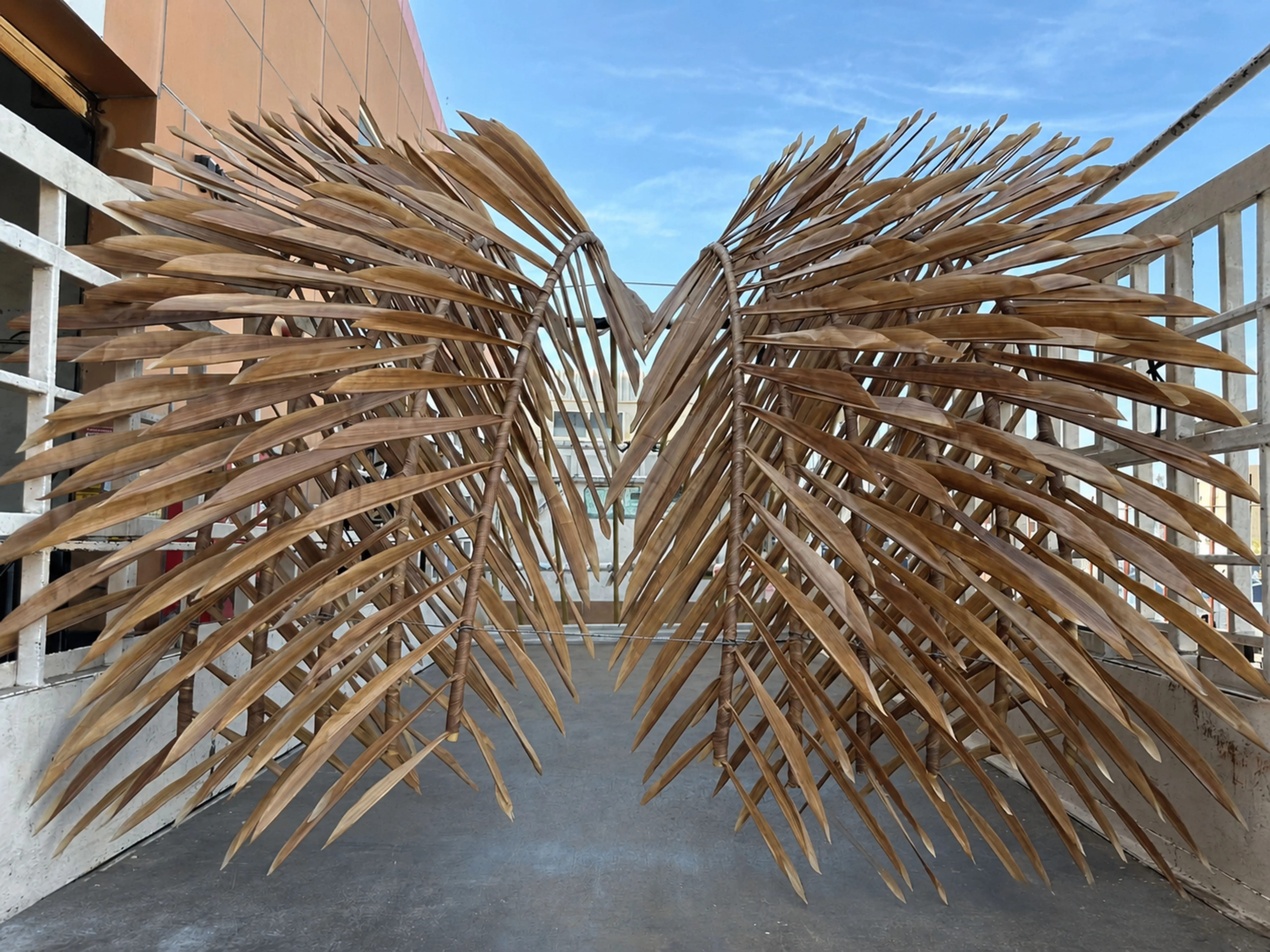 Pair of palm fronds with metal armature spines and printed fabric leaves, mid-fabrication on the NSQD rooftop
